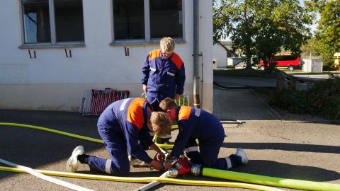 Auch die Jugendfeuerwehr war vertreten. Timo Stauder, Leon Jäckle (stehend) und Jonas Jäckle  schließen einen D-Schlauch aus dem neuen Set an den Verteiler an
